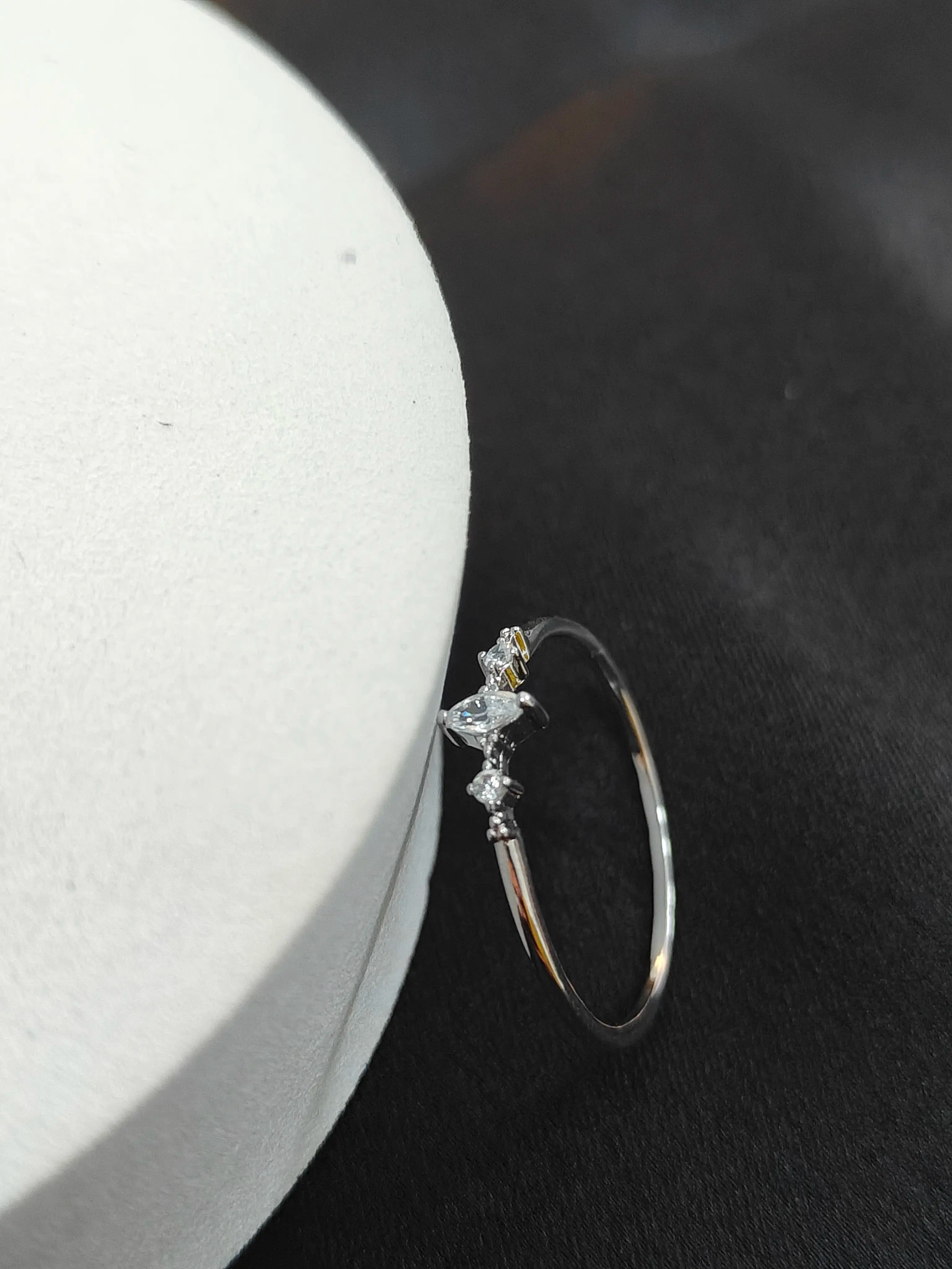 Silver ring with gemstones on a dark surface